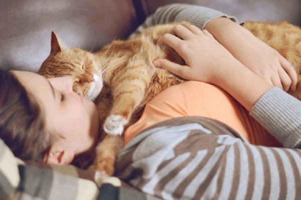 ragazza dorme con il suo gatto