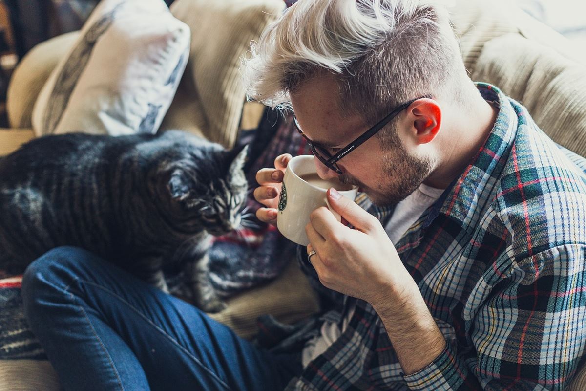 ragazzo beve un tè con il gatto