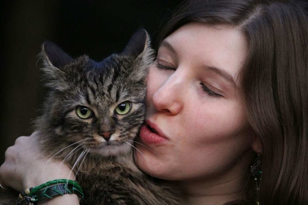 tagazza che bacia un gatto