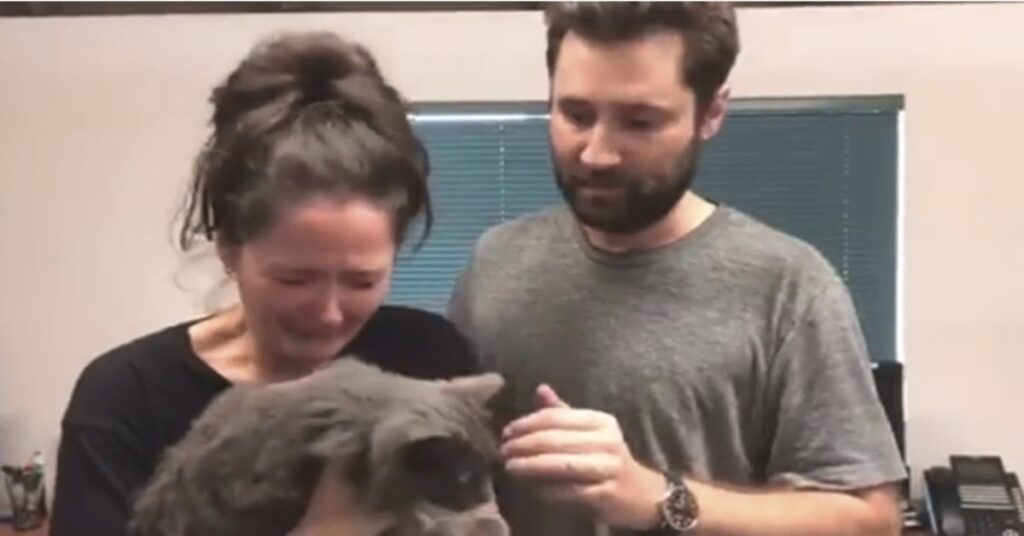 donna in lacrime con il suo gatto ritrovato