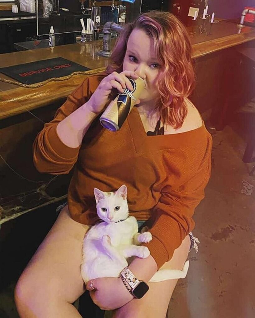 ragazza beve birra con il gatto