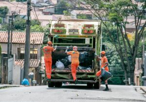 Lo spazzino interrompe momentaneamente il suo lavoro per giocare con un gatto randagio