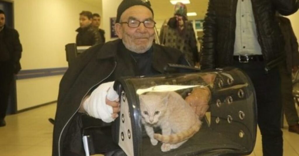 Un anziano abbraccia forte il suo gatto, dopo aver perso tutto in un incendio