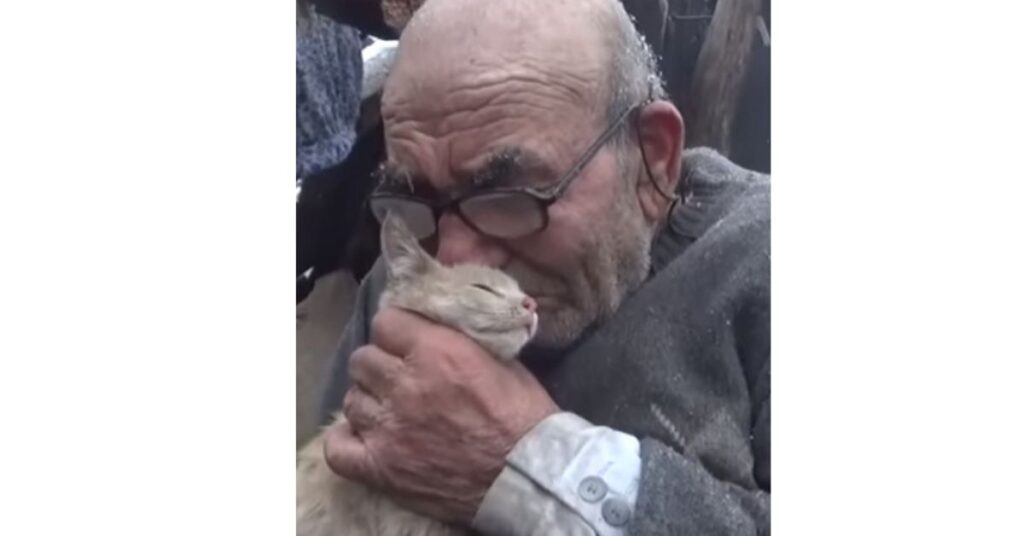 Un anziano abbraccia forte il suo gatto, dopo aver perso tutto in un incendio