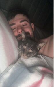 un gatto dorme con il suo papà adottivo