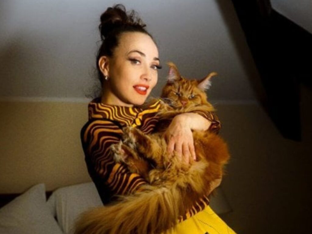 donna con capelli raccolti che tiene in braccio un gatto